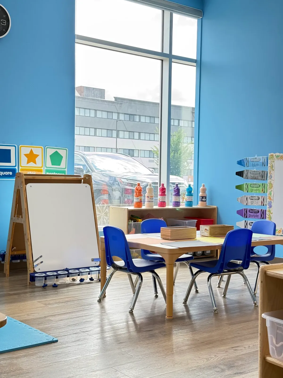 Art corner with an easel, paints and a table with small chairs